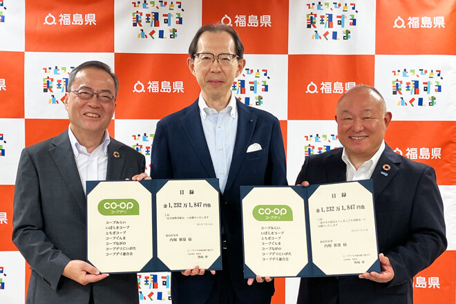 福島県の内堀雅雄知事（中央）に目録を渡す、コープデリにいがたの登坂康史代表理事理事長（左）とコープデリ連合会の熊﨑伸代表理事理事長（右）
